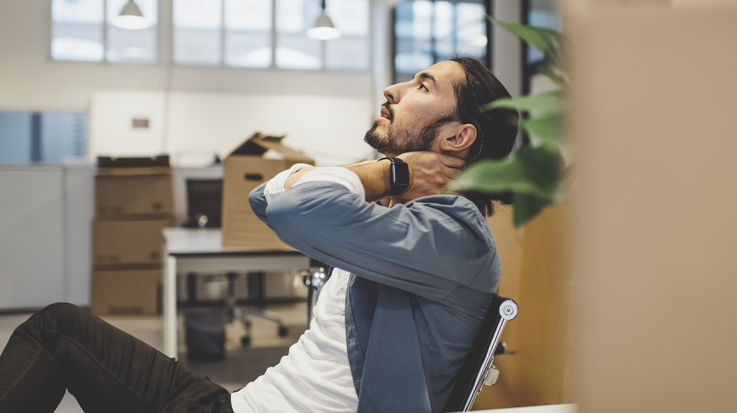 Die Verspannung im Nacken massiert sich ein junger Mann, der auf einem Bürostuhl sitzt, einfach weg Die Verspannung im Nacken massiert sich ein junger Mann, der auf einem Bürostuhl sitzt, einfach weg